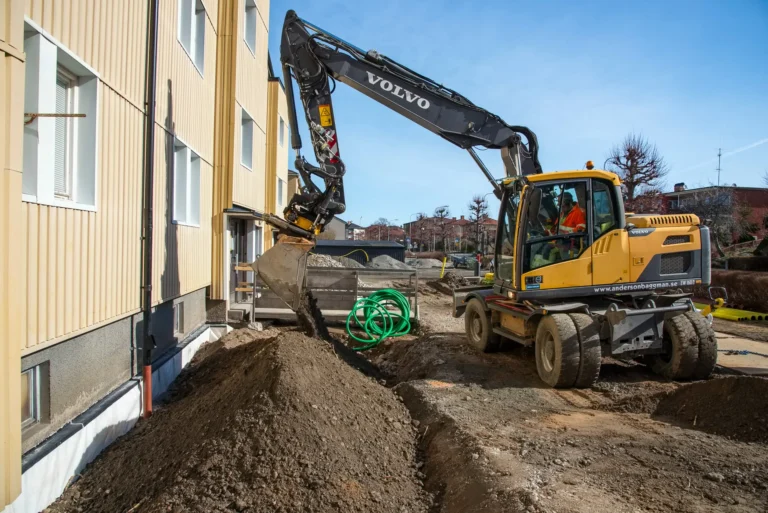 Grävmaskin fyller igen med material.